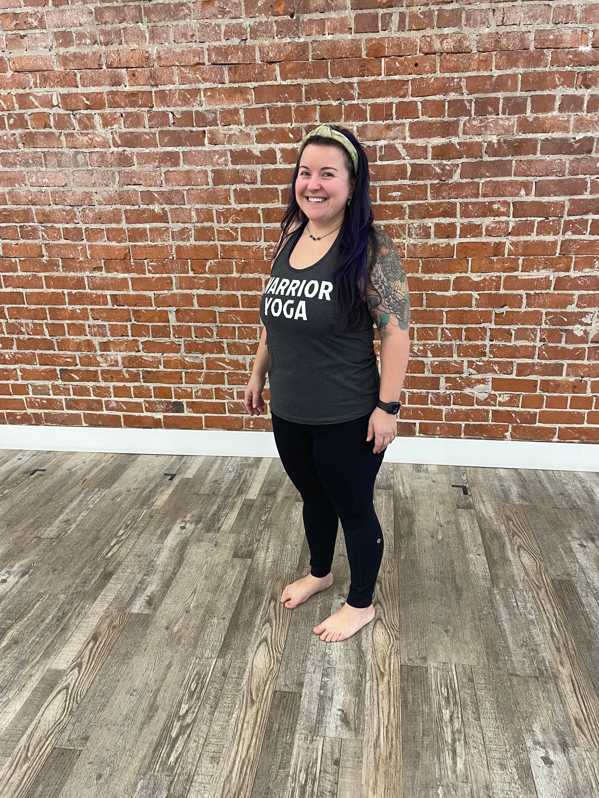 JRP Health Client Before and after transformation photos of a woman in a 'WARRIOR YOGA' tank top, smiling against a brick wall backdrop, highlighting her weight loss progress, vibrant personality, and commitment to her fitness journey